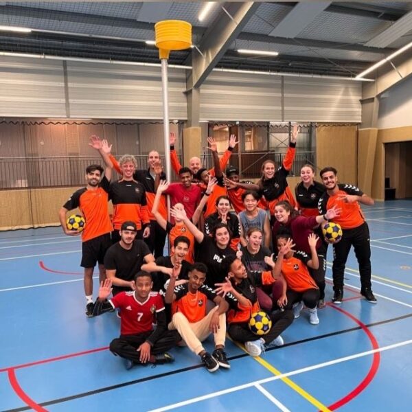 Het nieuwkomersteam van MIA poseert vrolijk onder de korf. Het sportplezier straalt er vanaf.